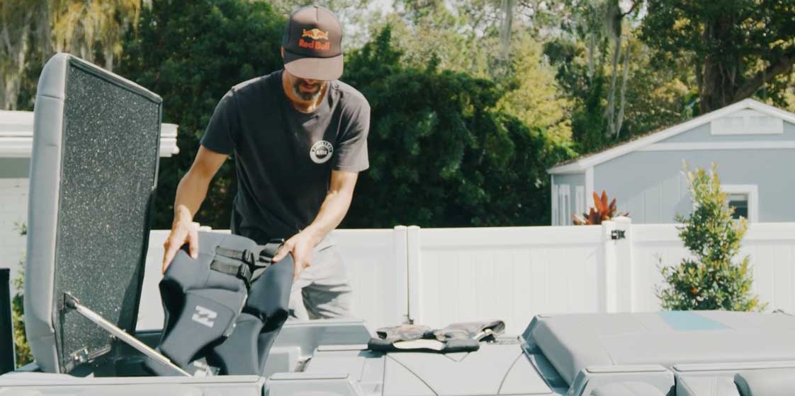 Man unloading lifejackets from a boat compartment